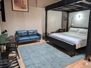 a bedroom with a bed and a couch and a table at The Well Hotel & Taproom in Trinidad