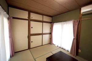 a room with a room with a window and a room with at ライダーハウスみかさんち in Marugame