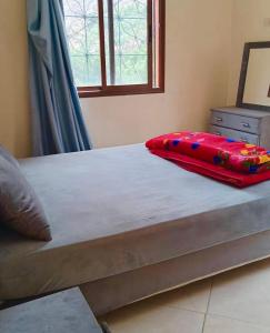 a bed with a red pillow on top of it at DAR LAHCEN - Terrace & Mountain View in Ourika