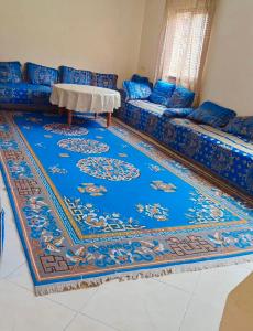 a living room with a blue couch and a blue rug at DAR LAHCEN - Terrace & Mountain View in Ourika