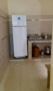 a small kitchen with a white refrigerator in a room at DAR LAHCEN - Terrace & Mountain View in Ourika