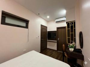a small room with a bed and a desk and a room at Valoria Premium Hanoi Hotel and Travel in Hanoi