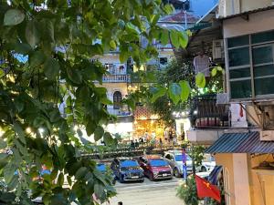 a city street with cars parked in front of buildings at Valoria Premium Hanoi Hotel and Travel in Hanoi
