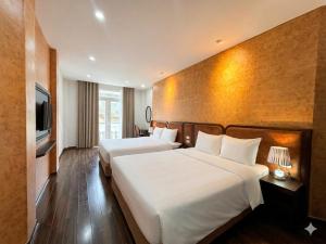 a hotel room with two beds and a television at Valoria Premium Hanoi Hotel and Travel in Hanoi