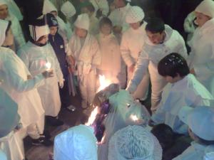 Un gruppo di persone in uniforme bianca che taglia una torta di Resort Isola Rossa a Bosa