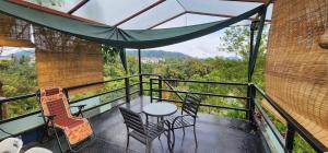 a balcony with chairs and a table with a view at Sameer Mountain View Retreat in Tanah Rata +5 photos