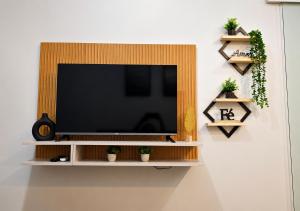 a flat screen tv on a wall with plants at Casa Harmonia - Ar Condicionado in Bom Jesus da Lapa