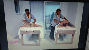 two women standing next to a man in two beds at Shiri Beach Resort in Zanzibar City