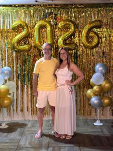 a man and a woman standing in front of a gold sign at Pousada Anturio in Barra Velha