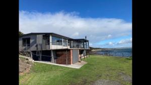 a house on the shore of a body of water at Stanley View Beach House in Crayfish Creek