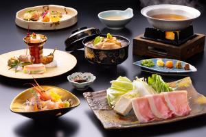 a table with plates of food and bowls of food at Yamanaka Onsen Kagari Kisshotei in Kaga +67 photos