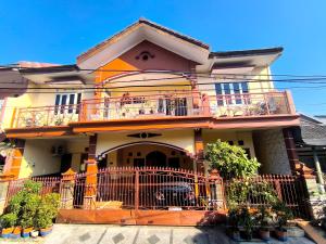 a large house with a balcony on a street at Sierra Homestay Malang 3 BR AC in Ngadipuro