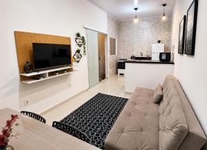 a living room with a couch and a television at Casa Harmonia - Ar Condicionado in Bom Jesus da Lapa +6 photos