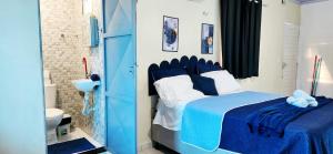 a blue and white bedroom with a bed and a bathroom at Mini Apartamentos na entrada de Tutóia in Tutóia