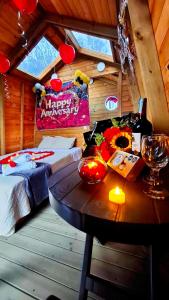 a bedroom with a bed and a table with a happy anniversary sign at La Nebulosa Glamping in Vergara