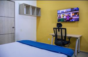 a bedroom with a desk and a chair and a tv at Muramar 43 Hotel Cartagena in Cartagena de Indias