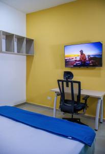 a room with a desk and a tv on a wall at Muramar 43 Hotel Cartagena in Cartagena de Indias