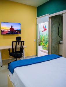 a bedroom with a bed and a tv on the wall at Muramar 43 Hotel Cartagena in Cartagena de Indias