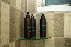 three shampoo bottles on a shelf in a bathroom at Apartamento Morada dos Sonhos in Lauro de Freitas +57 photos