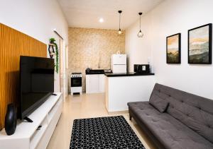 a living room with a couch and a kitchen at Casa Harmonia - Ar Condicionado in Bom Jesus da Lapa