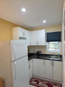 a kitchen with white cabinets and a white refrigerator at Lakeview Motel & Cottage in Kincardine