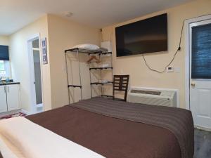 a bedroom with a bed and a flat screen tv at Lakeview Motel & Cottage in Kincardine