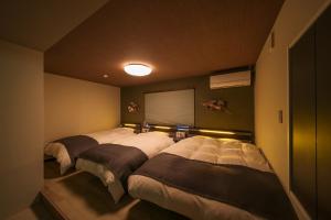 a bedroom with two beds and a window at 在-Zai- in Beppu