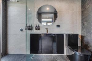 a bathroom with a sink and a mirror at Hobart Retreats - Sanctuary and Haven in Hobart +36 photos