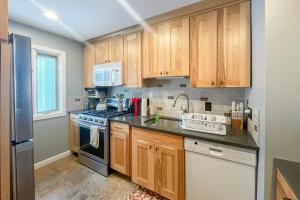 a kitchen with wooden cabinets and a stove top oven at Waterville Vacation Condo in Waterville Valley
