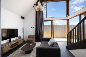 a living room with a couch and a tv at Hobart Retreats - Sanctuary and Haven in Hobart