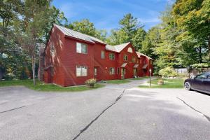 a red barn with a car parked in front of it at Cozy Condo In The Woods in Lincoln