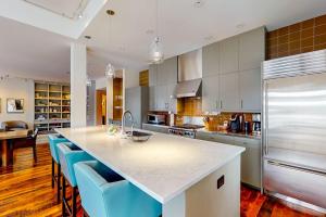 a kitchen with a large island with blue chairs at Precious Pearl in Jackson +22 photos