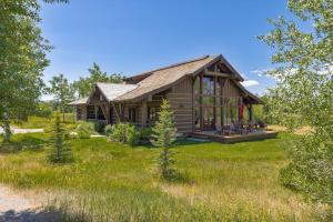a log cabin in the middle of a yard at Serenity in the Valley in Jackson