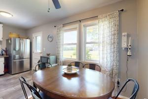 a dining room with a wooden table and a kitchen at Gloucester Getaway in Gloucester