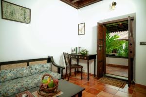 a living room with a couch and a table at SVS Arena in Kizhake Chālakudi