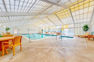 a large swimming pool in a large room with a table and chairs at Autumn Colors Condo, Unit 215 in Lincoln