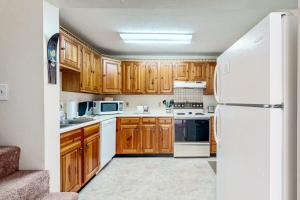 a kitchen with wooden cabinets and a white refrigerator at Four Seasons Retreat in Bartlett