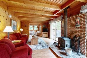 a living room with a red couch and a fireplace at Saco River Hideaway in Bartlett