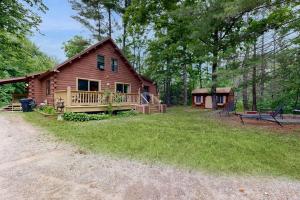 a log cabin with a porch and a yard at Saco River Hideaway in Bartlett