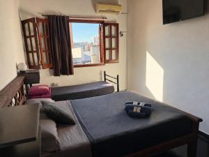 a bedroom with two twin beds and a window at Güemes Hostel Cordoba in Córdoba