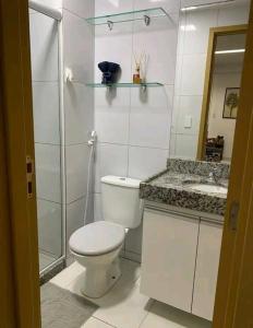 a white bathroom with a toilet and a sink at Apt Completo com Vista para o Mar, Ar Condicionado e Café da Manhã Opcional in Recife