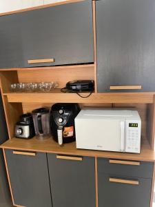 a microwave sitting on a shelf in a kitchen at Casa grande in Garanhuns