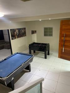a ping pong table in a room with a pool table at Casa grande in Garanhuns