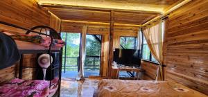 a room with a bed and a television in a cabin at Sameer Mountain View Retreat in Tanah Rata