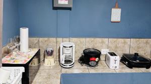 a kitchen counter with various appliances on a blue wall at Apartamento El Almendro in Liberia +9 photos