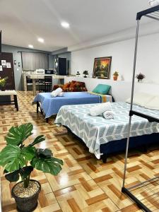 a bedroom with two beds and a kitchen with a table at Apartamento El Almendro in Liberia