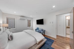 a white bedroom with a bed and a chair at Downtown Delight in Jackson