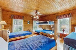 a bedroom with three bunk beds in a log cabin at Chez Normand in Jefferson