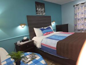 a bedroom with two beds and a table with a chair at Lakeview Motel & Cottage in Kincardine +32 photos