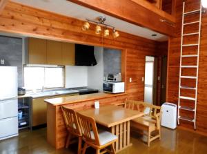 a kitchen with a table and chairs in a room at 北軽井沢 SPAHA Karuizawa Forest Resort Villa YB1 in Kita-karuizawa